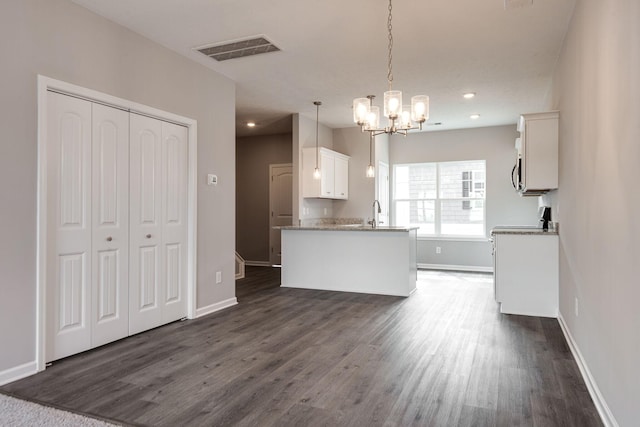 kitchen with hanging light fixtures, a chandelier, dark hardwood / wood-style floors, and white cabinets