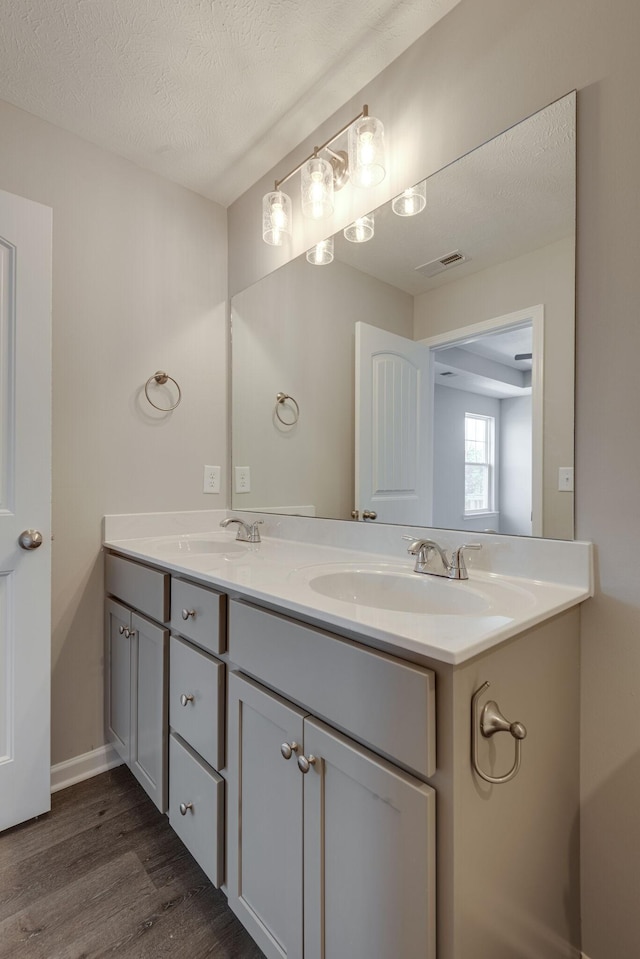 bathroom featuring vanity, wood-type flooring, and a textured ceiling