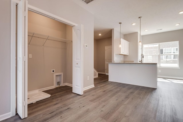 washroom featuring dark wood-type flooring, hookup for an electric dryer, and sink