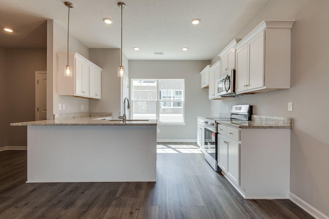 kitchen featuring sink, decorative light fixtures, white cabinets, and appliances with stainless steel finishes