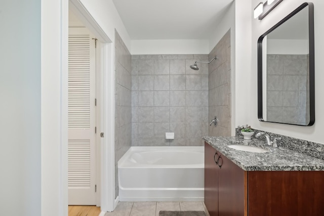 bathroom with tile patterned floors, tiled shower / bath combo, and vanity