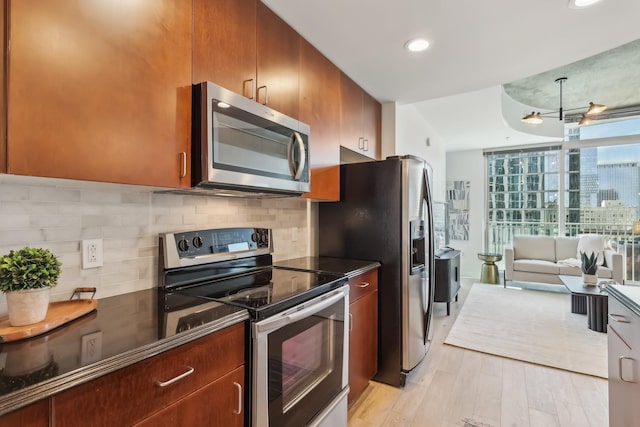 kitchen featuring backsplash, light hardwood / wood-style flooring, and appliances with stainless steel finishes