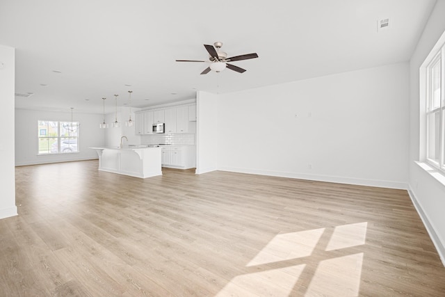 5061 Greentree Dr, Smyrna, TN 37167 - unfurnished living room with light wood-type flooring, baseboards, ceiling fan, and a sink