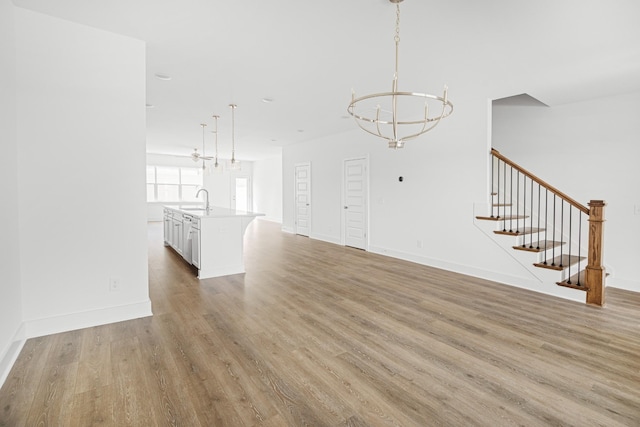 5061 Greentree Dr, Smyrna, TN 37167 - unfurnished living room with a sink, a chandelier, light wood-type flooring, stairway, and baseboards