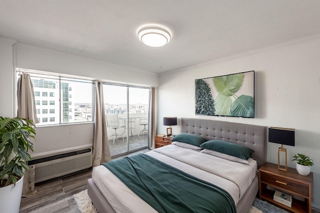 bedroom with access to exterior, wood-type flooring, ornamental molding, and an AC wall unit