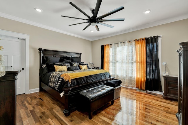 bedroom with crown molding, ceiling fan, and hardwood / wood-style floors