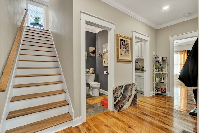 stairs with crown molding and hardwood / wood-style floors