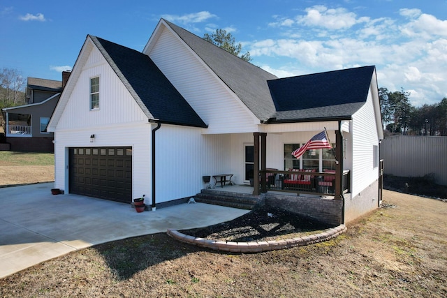 modern farmhouse with a porch, a garage, and a front lawn