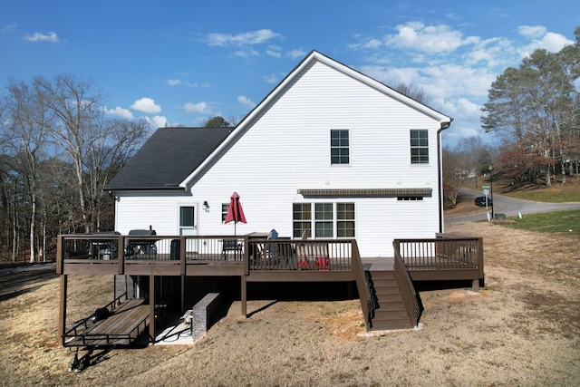 back of property featuring a wooden deck and a lawn