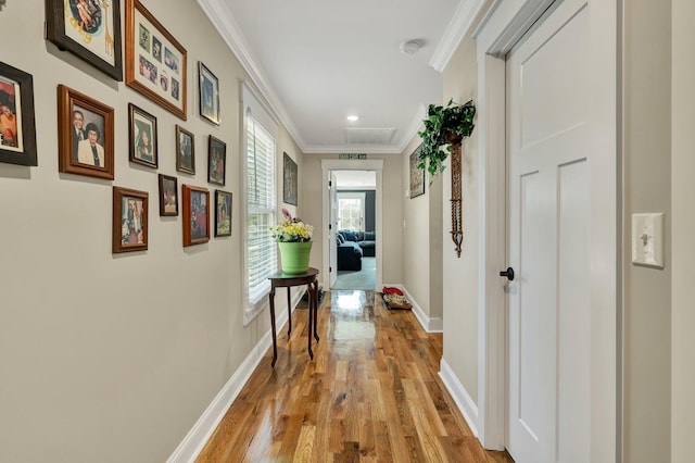 hallway featuring crown molding and light hardwood / wood-style flooring