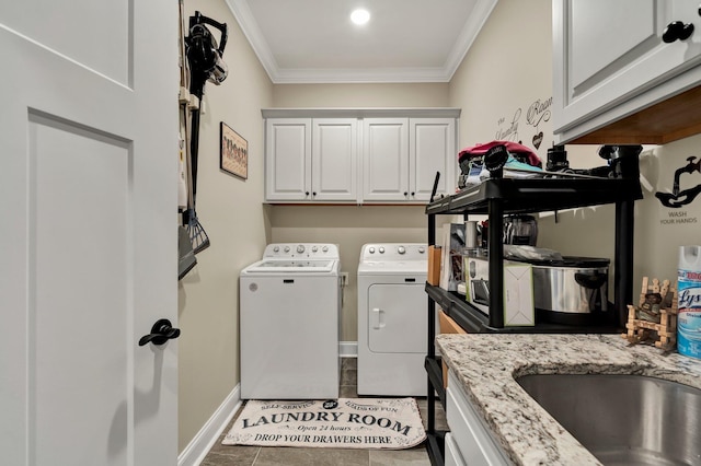 laundry room featuring cabinets, washing machine and dryer, ornamental molding, and tile patterned floors