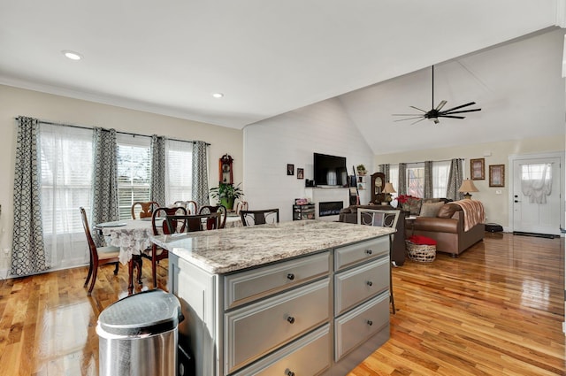 kitchen featuring gray cabinetry, light hardwood / wood-style floors, a kitchen island, and a wealth of natural light