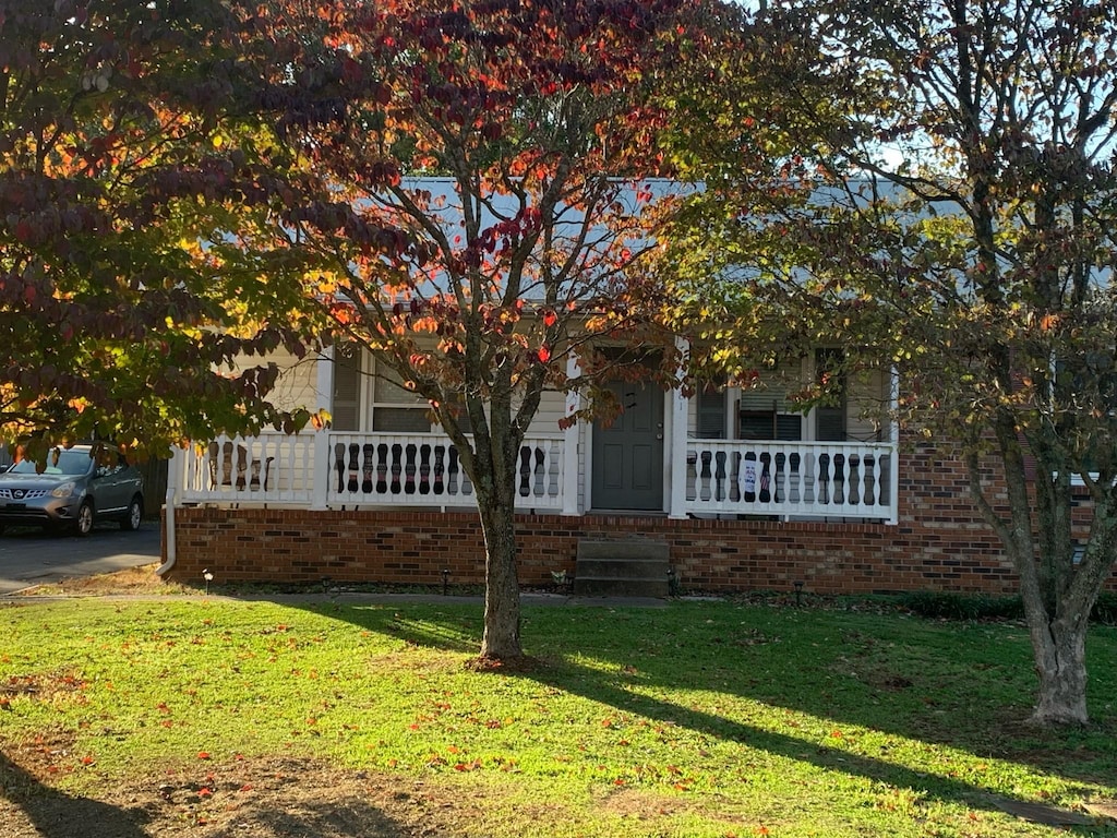 view of property hidden behind natural elements featuring a front lawn