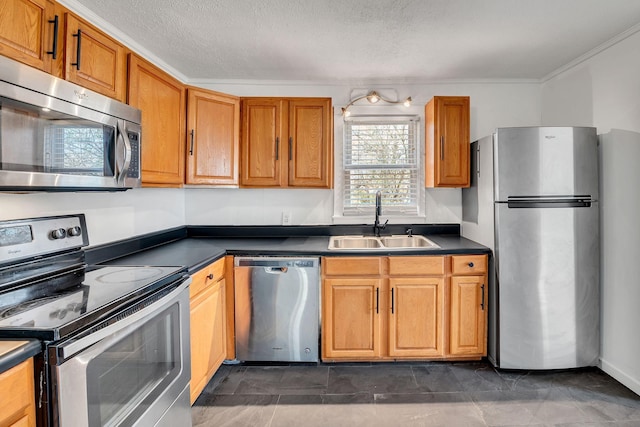 kitchen featuring ornamental molding, appliances with stainless steel finishes, sink, and a textured ceiling