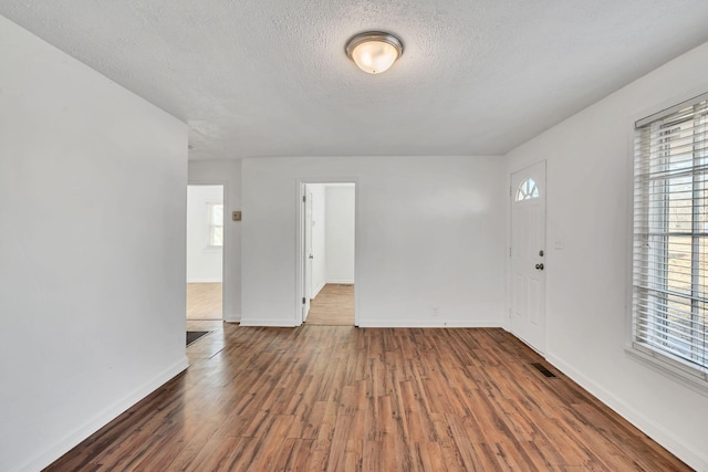 entrance foyer with a textured ceiling and dark hardwood / wood-style flooring