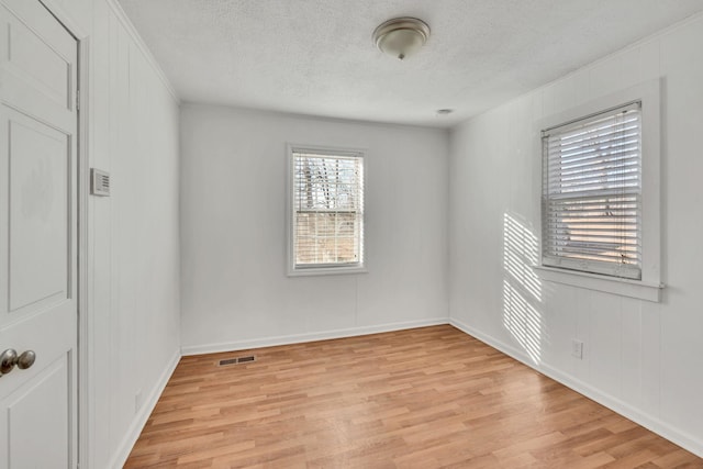 empty room featuring light hardwood / wood-style floors and a textured ceiling