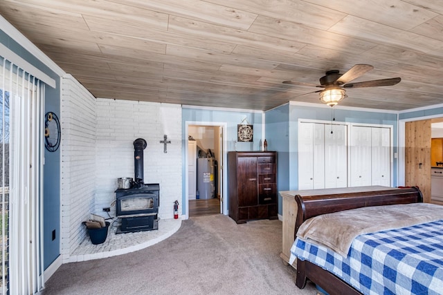 bedroom featuring electric water heater, a wood stove, light colored carpet, and ceiling fan