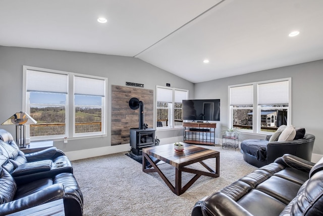 carpeted living room featuring lofted ceiling and a wood stove