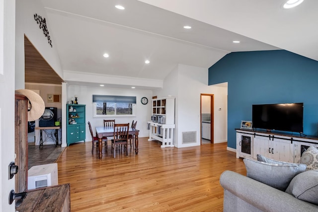 living room featuring light hardwood / wood-style flooring and vaulted ceiling