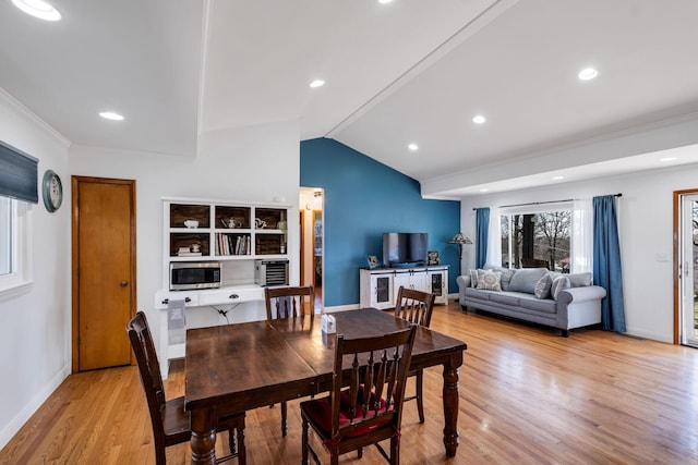 dining room with lofted ceiling and light hardwood / wood-style flooring