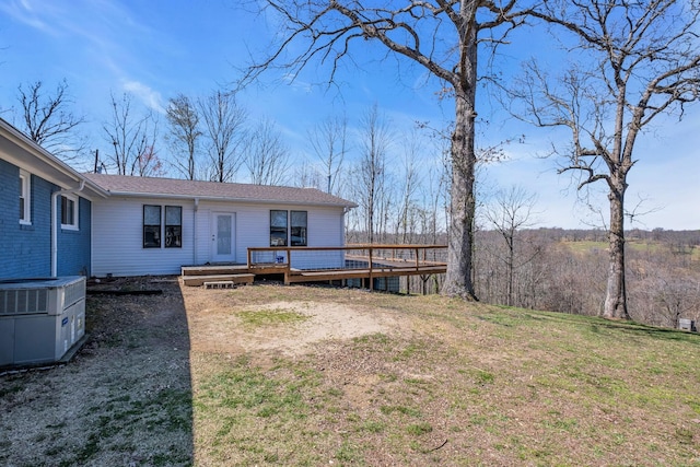 exterior space with central AC, a deck, and a lawn