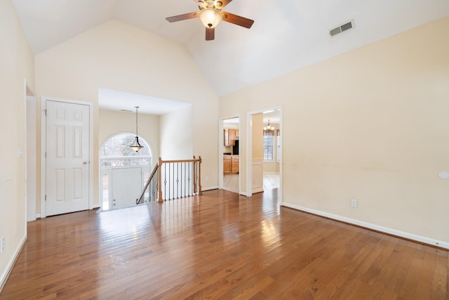 empty room with ceiling fan, high vaulted ceiling, and dark hardwood / wood-style flooring