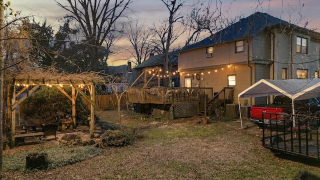 yard at dusk with a wooden deck and an outdoor fire pit