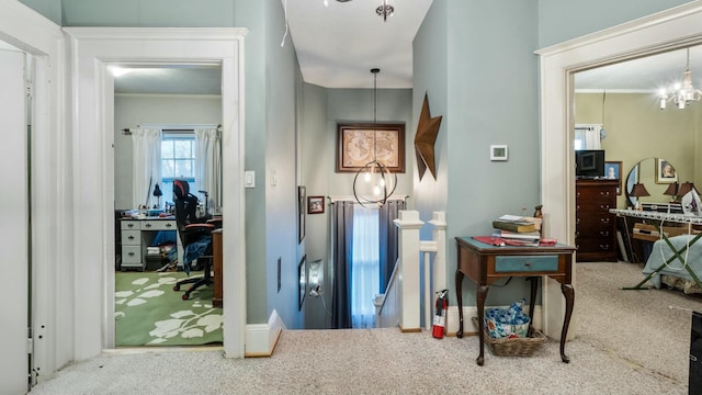 hallway with carpet flooring and a notable chandelier