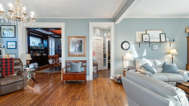 living room with an inviting chandelier, crown molding, and hardwood / wood-style flooring