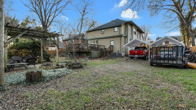 view of yard featuring a wooden deck, central AC unit, and a fire pit