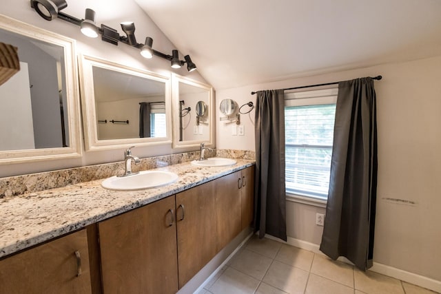 full bathroom featuring double vanity, tile patterned floors, vaulted ceiling, and a sink