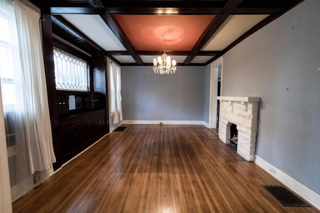 unfurnished living room featuring visible vents, baseboards, dark wood-style floors, an inviting chandelier, and coffered ceiling