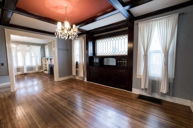 interior space with visible vents, wood finished floors, baseboards, an inviting chandelier, and coffered ceiling