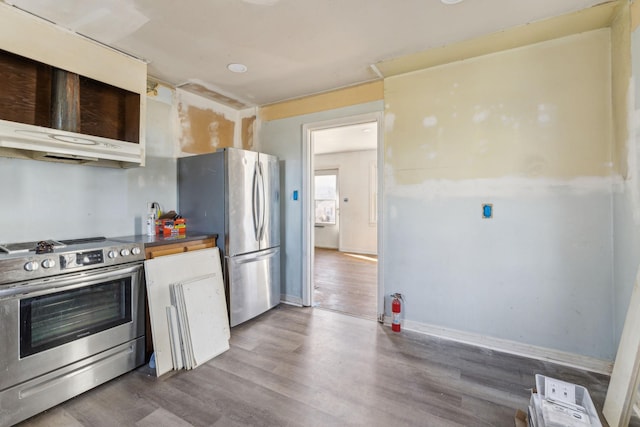 kitchen with stainless steel appliances, dark hardwood / wood-style floors, and exhaust hood