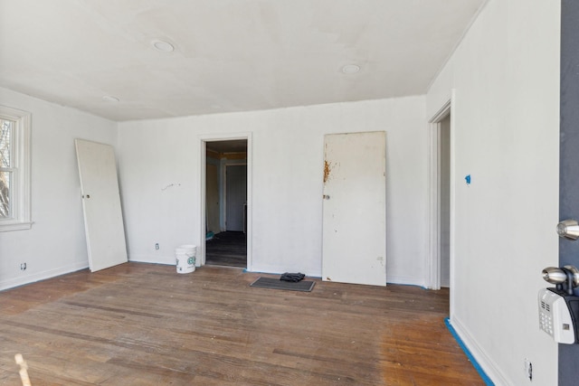 unfurnished room with dark hardwood / wood-style flooring