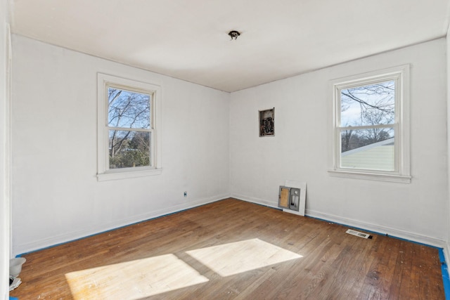 unfurnished room with a wealth of natural light and wood-type flooring