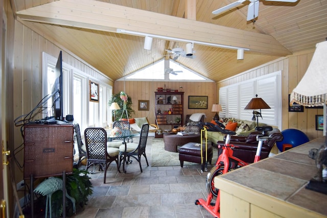 dining area featuring ceiling fan, a healthy amount of sunlight, and wooden walls