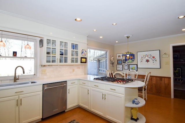 kitchen featuring decorative light fixtures, sink, ornamental molding, kitchen peninsula, and stainless steel appliances