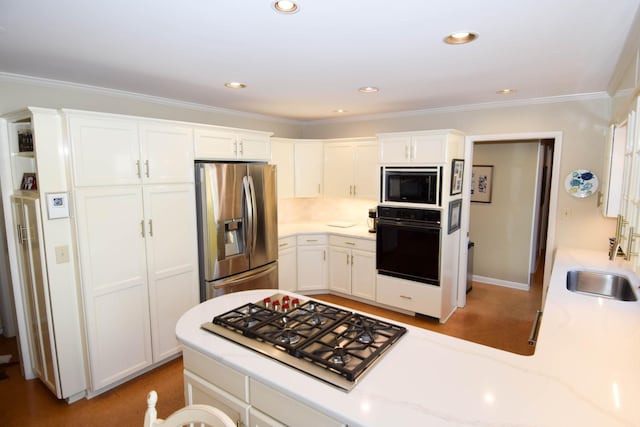 kitchen with white cabinetry, sink, ornamental molding, and stainless steel appliances