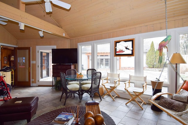 living room with wood ceiling, vaulted ceiling, wooden walls, and ceiling fan