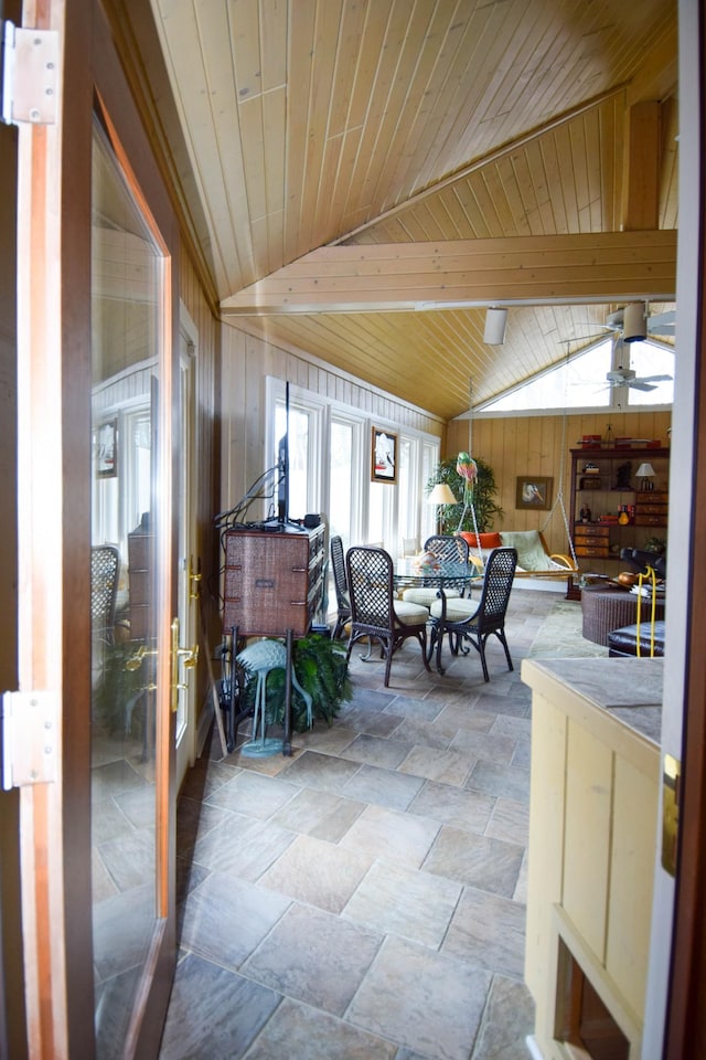 dining room featuring wood ceiling, lofted ceiling, and wooden walls