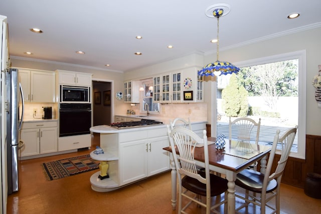 kitchen with hanging light fixtures, white cabinets, and black appliances