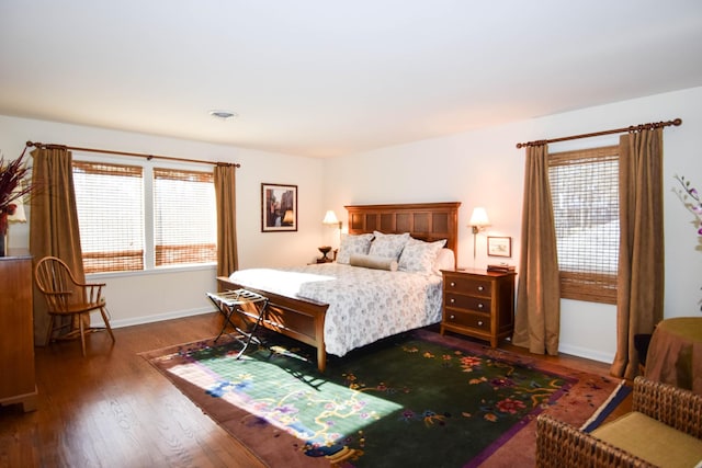 bedroom with multiple windows and dark hardwood / wood-style flooring