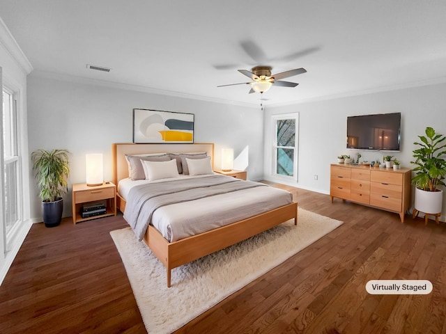 bedroom with ornamental molding, dark hardwood / wood-style floors, and ceiling fan