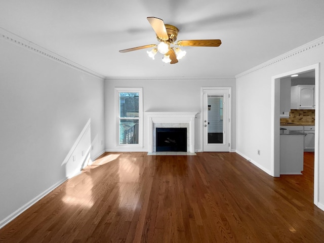 unfurnished living room with dark hardwood / wood-style flooring, ornamental molding, and ceiling fan