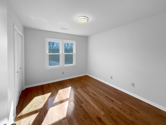 unfurnished bedroom featuring dark wood-type flooring and a closet