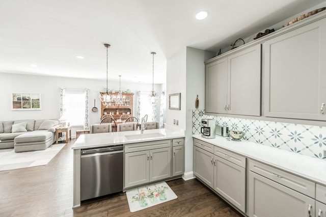 kitchen featuring decorative light fixtures, sink, stainless steel dishwasher, and kitchen peninsula