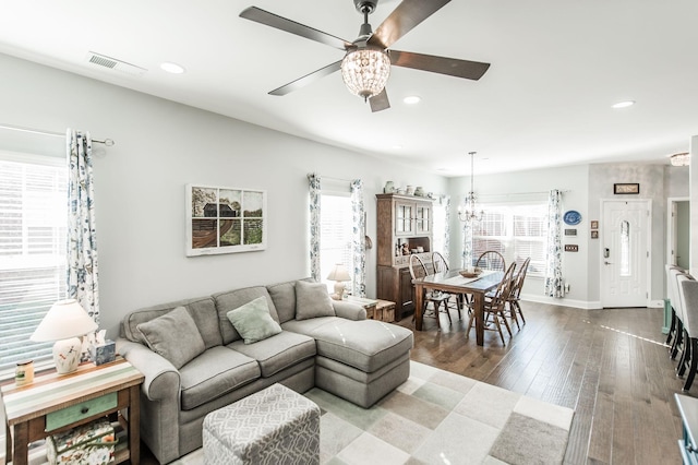 living room with hardwood / wood-style flooring and ceiling fan with notable chandelier