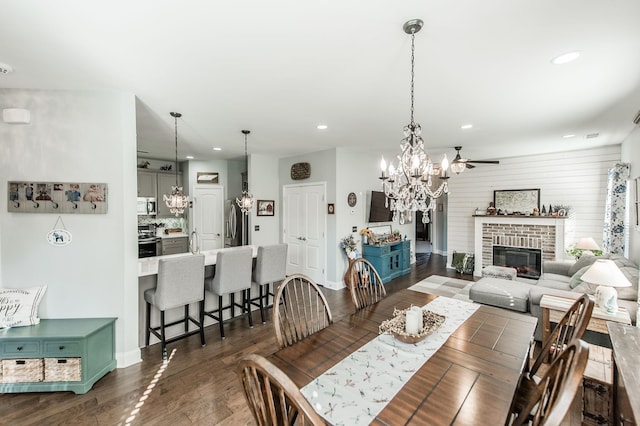 dining room with ceiling fan, dark hardwood / wood-style floors, and a fireplace