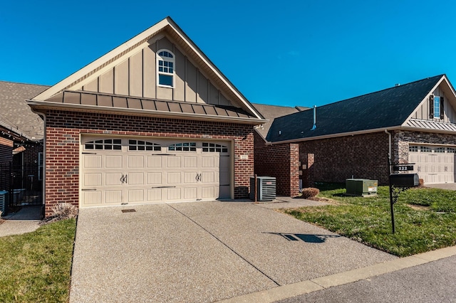 view of front of property featuring a garage, central AC, and a front lawn